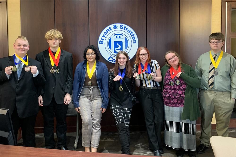  Seven students pose with their medals after a recent competition.